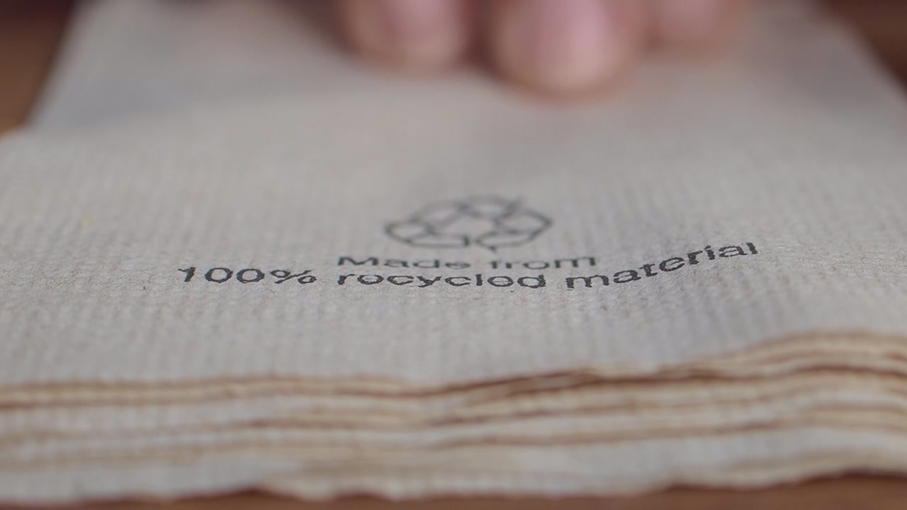 Hand Picking Up a Napkin Made from 100% Recycled Material