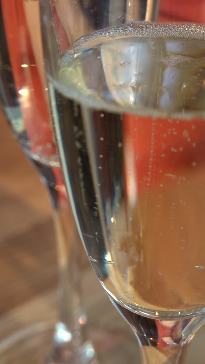 Close up of glasses of white sparkling wine on a table. Vertical