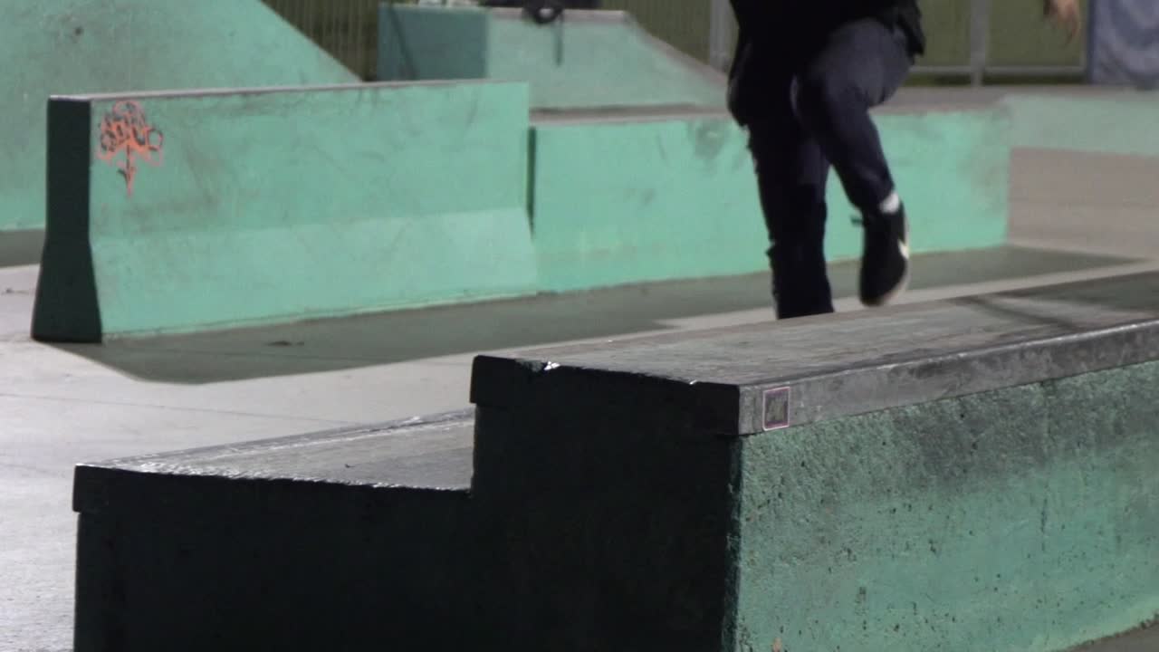 patinador en la noche haciendo un ollie a un tobogán de cola