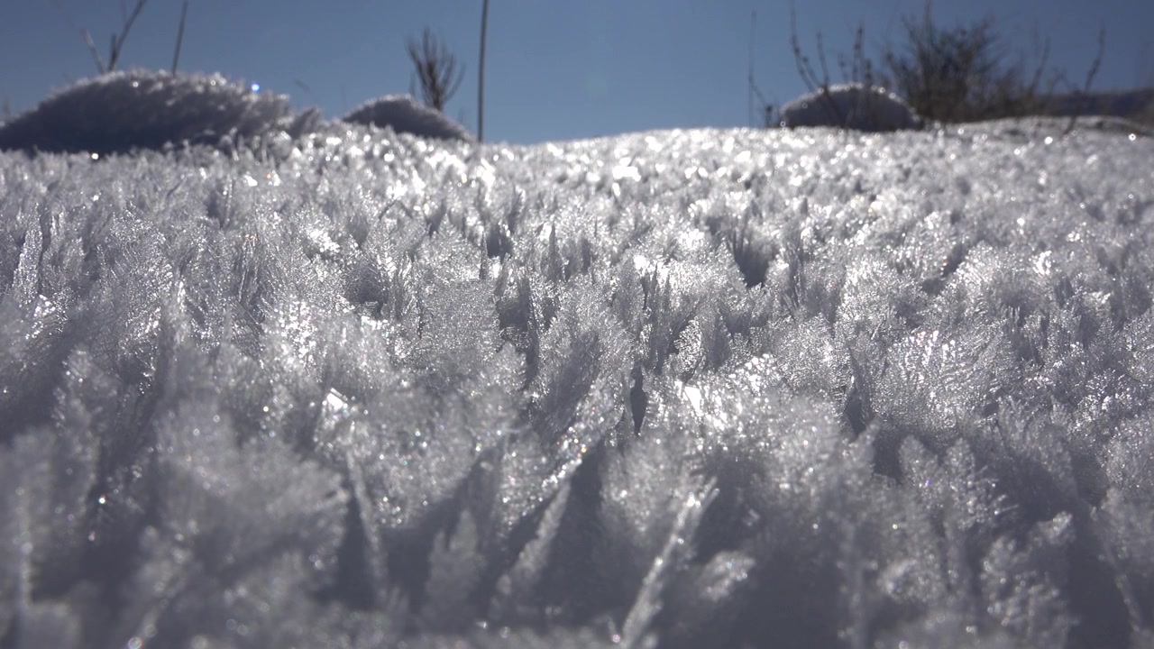 Nahaufnahme von Frostkristallen auf verschneitem Boden