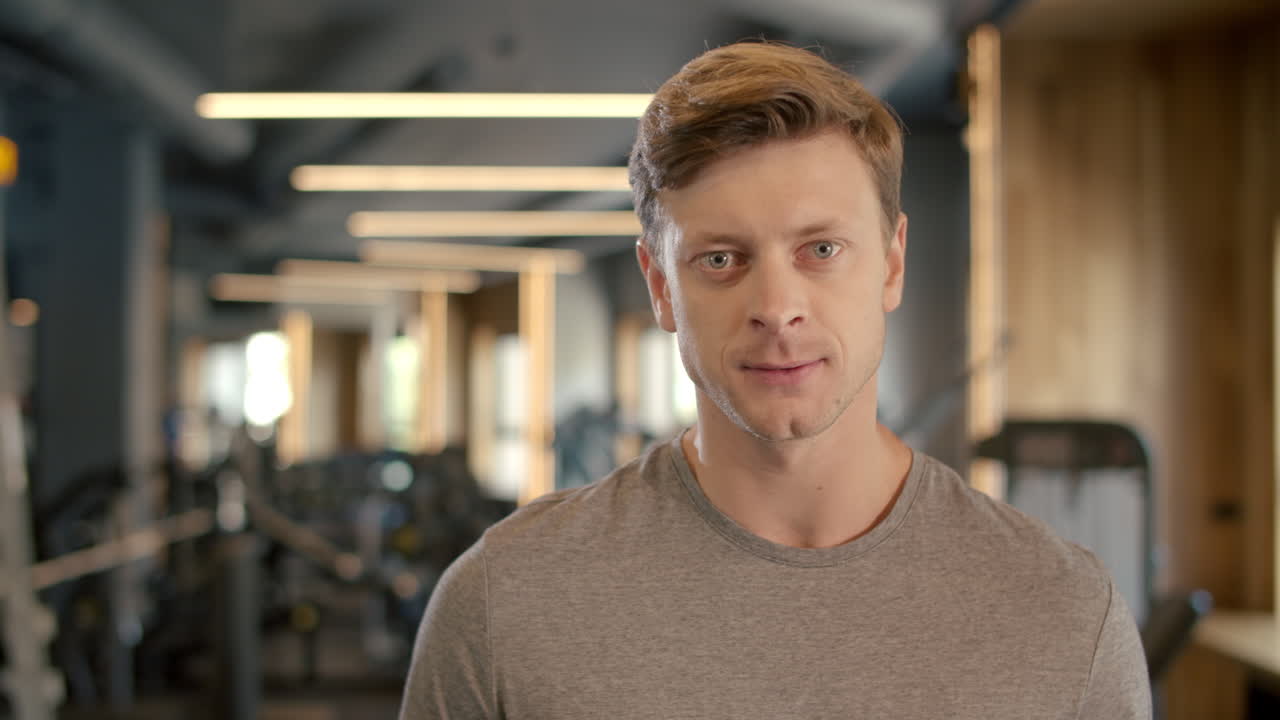 체육관에서 비명을 지르는 공격적인 보디빌더. 스포츠 클럽에 서 있는 스포츠맨