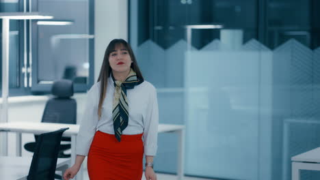 Hermosa-Joven-Jefa-Con-El-Pelo-Largo-Y-Oscuro-Vestida-Con-Camisa-Roja-Y-Camisa-Blanca-Caminando-Por-La-Oficina-Por-La-Noche-Con-Gran-Confianza-En-Cámara-Lenta