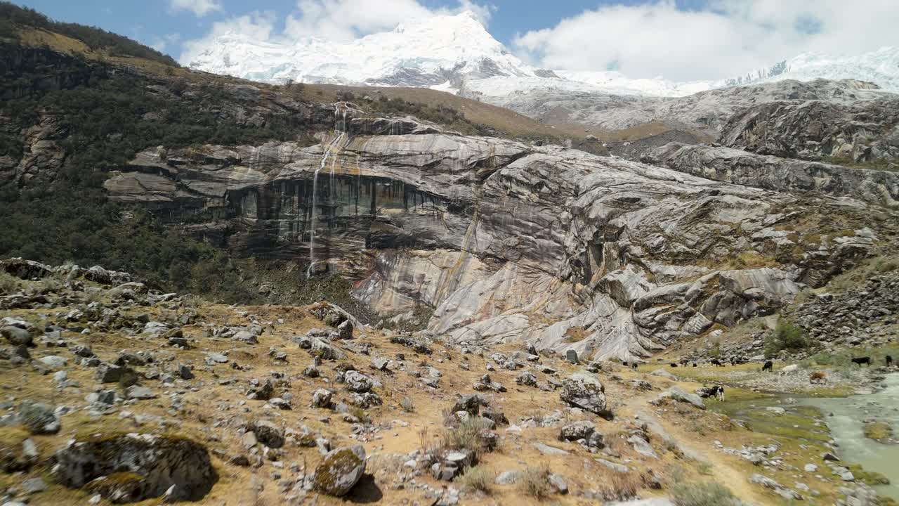 A thrilling, low-altitude drone shot flies rapidly over the rushing, whitewater stream that flows from the glacial waters of Laguna 513 in the high Andes of Peru