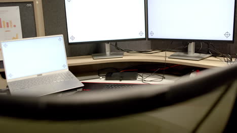 General-view-of-laptop-and-computers-with-blank-screens-in-office,-slow-motion