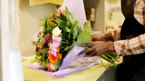 Female-florist-preparing-flower-bouquet-in-flower-shop-4k