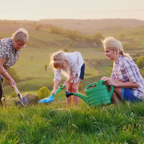 An-Elderly-Woman-With-Her-Daughter-And-Granddaughter-Together-Plant-A-Tree