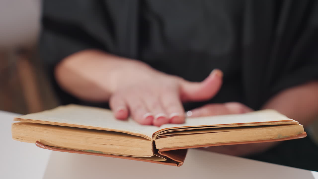 보존을 위해 정밀한 기술로 역사적 기록물을 주의 깊게 검토하고 보존하며, 기록 보관 조명 아래에서 오래된 책 페이지를 조심스럽게 넘기고 목록화해요.