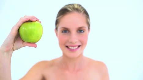 una mujer bonita con una manzana verde en la mano.