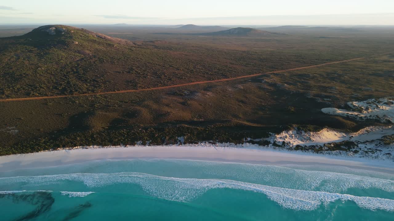 Surf at sunrise with mountains of Cape le Grand in the background