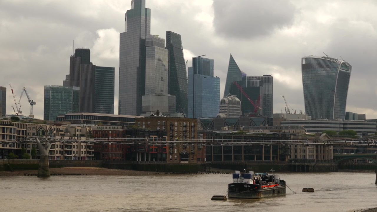 London skyline and financial district skyscrapers view from the River Thames under a cloudy sky