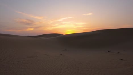 caminar sobre las increíbles dunas de arena de abu dhabi durante una magnífica puesta de sol naranja