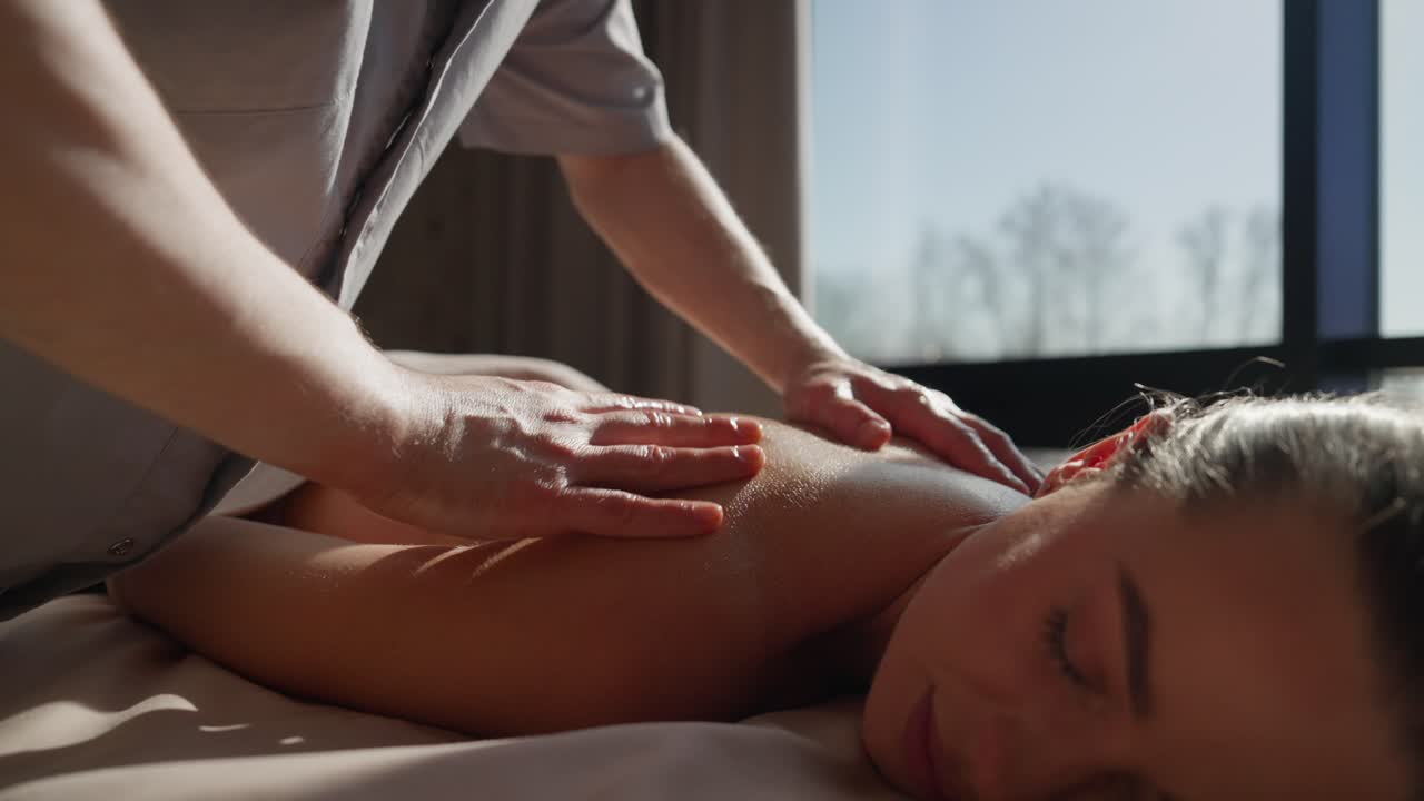 Professionel massør giver en afslappende rygmassage til en kvinde