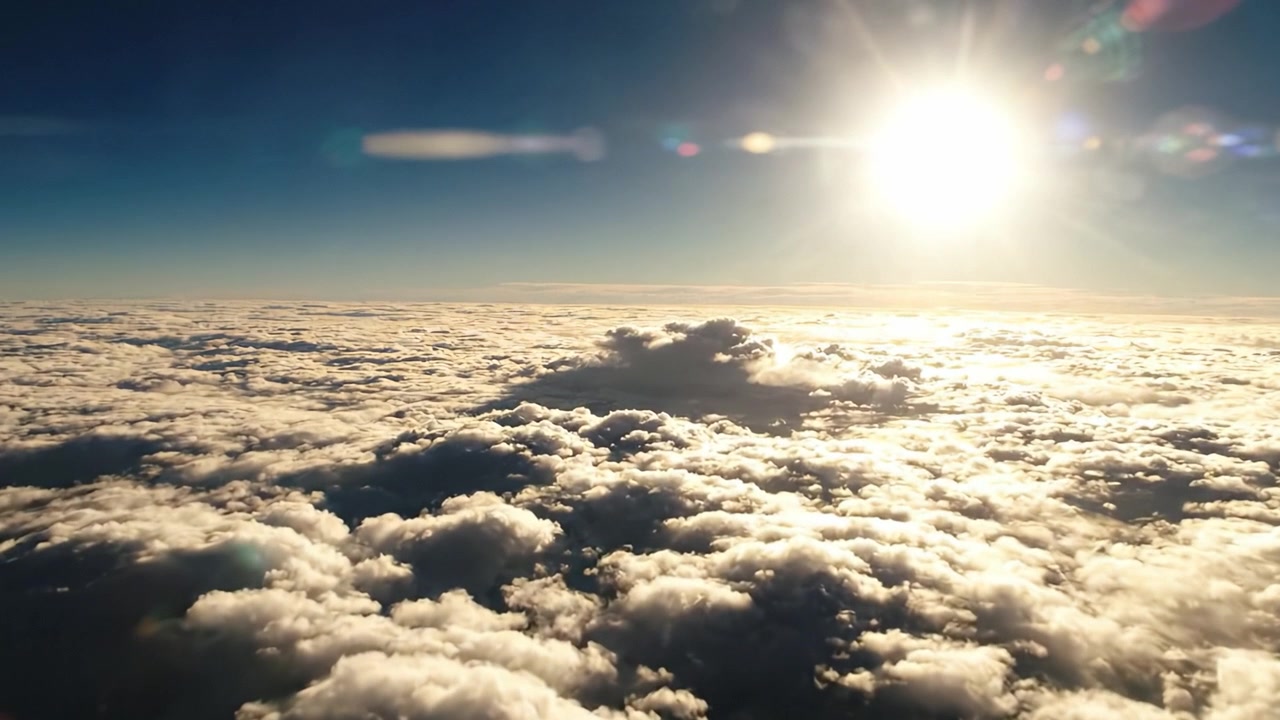 Vista mozzafiato di un cielo illuminato dal sole sopra le nuvole, che cattura la serenità e la bellezza del paesaggio naturale in una splendida prospettiva aerea.