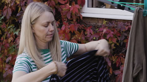 woman hanging laundry to dry outside