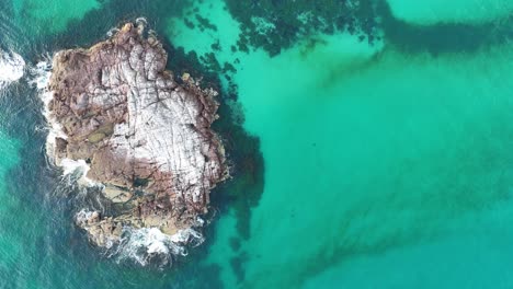 Nature's-Palette:-Aerial-View-of-Rocky-Shores-Meeting-Azure-Waters