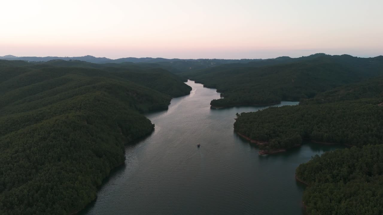 정글 언덕 근처 의 강 에 떠다니는 작은 관광 보트 의 멀리 있는 공중 풍경