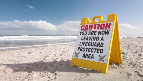 señal de precaución en la playa, ahora está saliendo de un área protegida por salvavidas