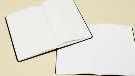 video of books with white blank pages and copy space on yellow background