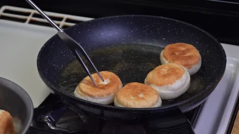 la mujer saca rosquillas con agujero del aceite caliente.