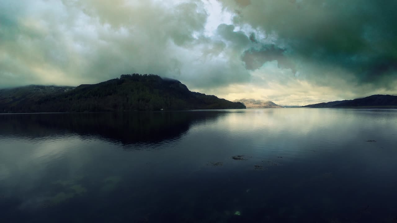 Dramatic Overcast Sky Reflected in Calm Mountain Loch