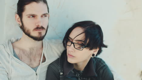 thoughtful young hipster couple they sit side by side on the windowsill dream dark-haired woman with