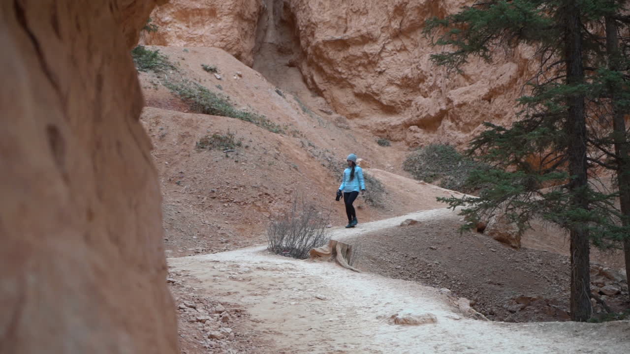 молодая женщина на пешеходной тропе в национальном парке брайс-каньон, штат юта, сша, замедленная съемка