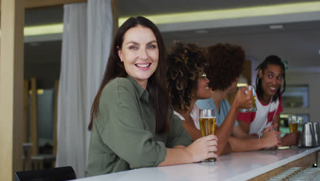 Eine-Vielfältige-Gruppe-Glücklicher-Freunde,-Die-In-Einer-Bar-Bier-Trinken-Und-Lächeln