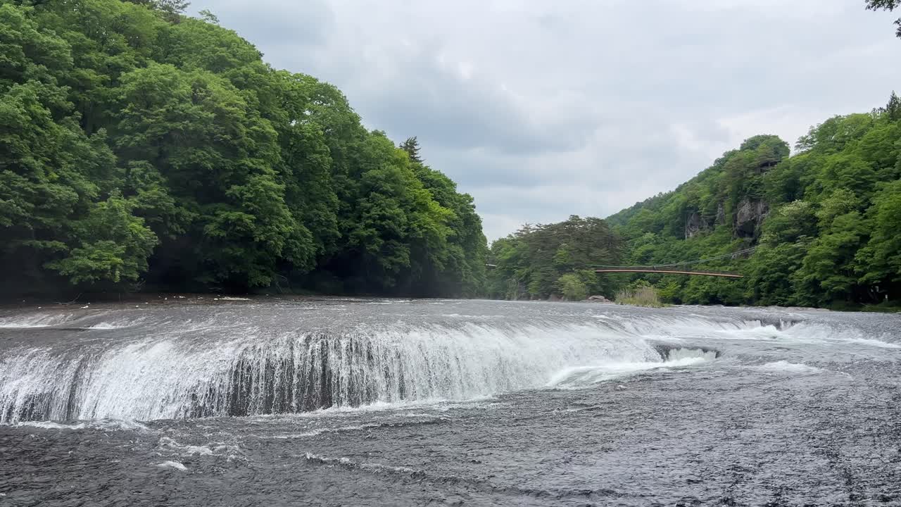 Incredible wide Fukiware waterfalls in lush green nature. Slow motion shot