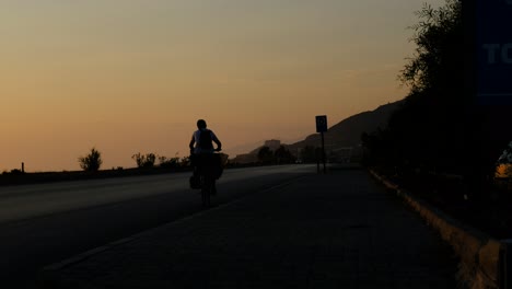 man riding bike sunset