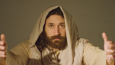 portrait of man wearing robes with long hair and beard representing figure of jesus christ raising hands in prayer 3