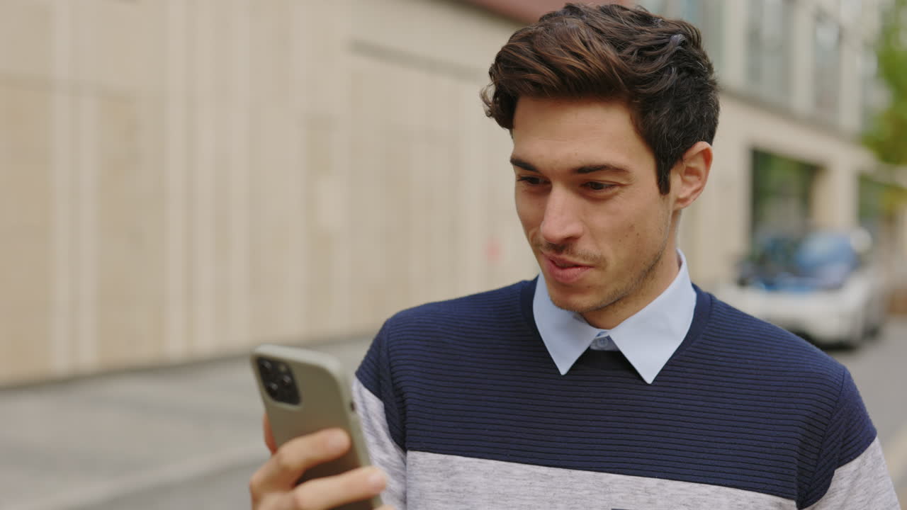 Man smiling while looking at his phone