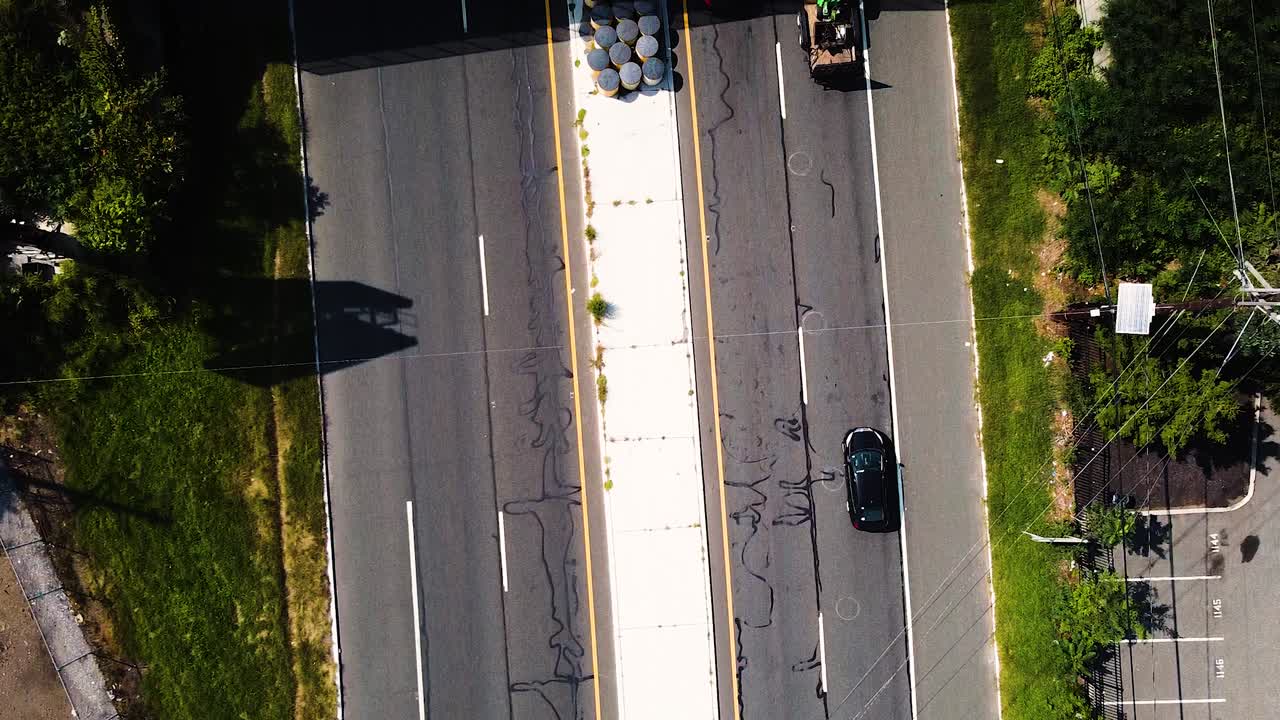 Aerial Flyover of trains crossing bridge over busy highway