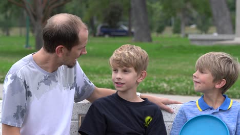 single dad hanging out with sons in park