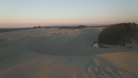 golden hour light on sand dunes of dunes city, oregon, low flyover, setting used as inspiration for dune films.