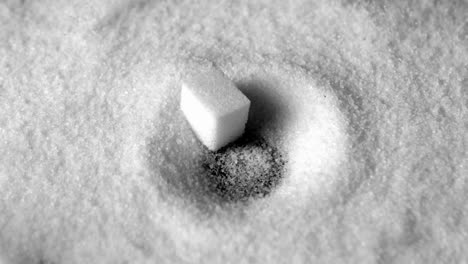 sugar cube falling in pile of sugar