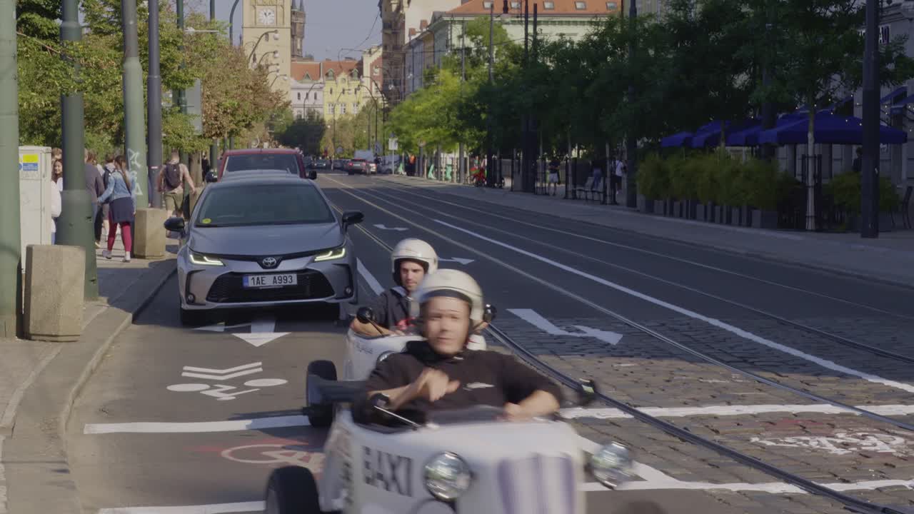Friends Enjoying a Joyride in Small Vintage Cars Through the Streets of Prague