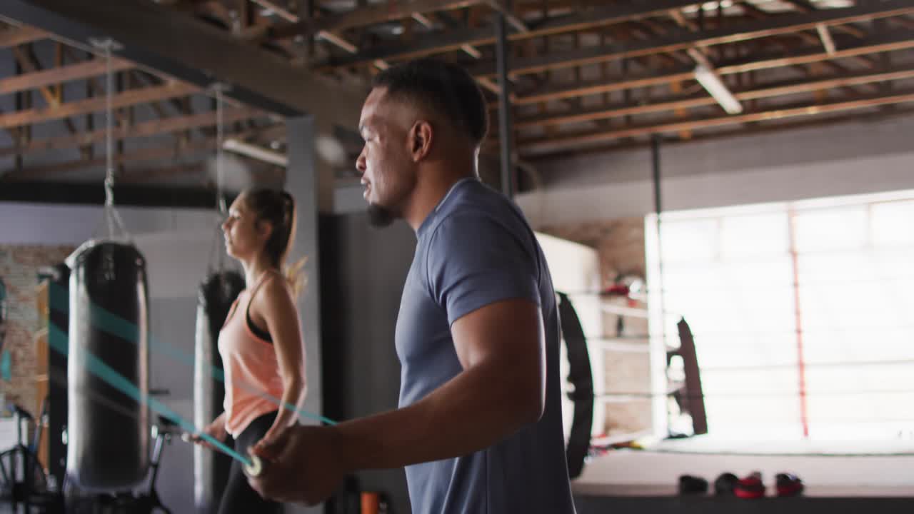 Two exercisers jumping rope on first swing, teal charts sweeping over them for fitness