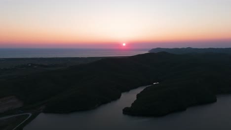 Colorida-Puesta-De-Sol-Aérea-Sobre-El-Mar-Adriático-Y-La-Ladera-De-Sombra-Oscura-Cerca-Del-Río