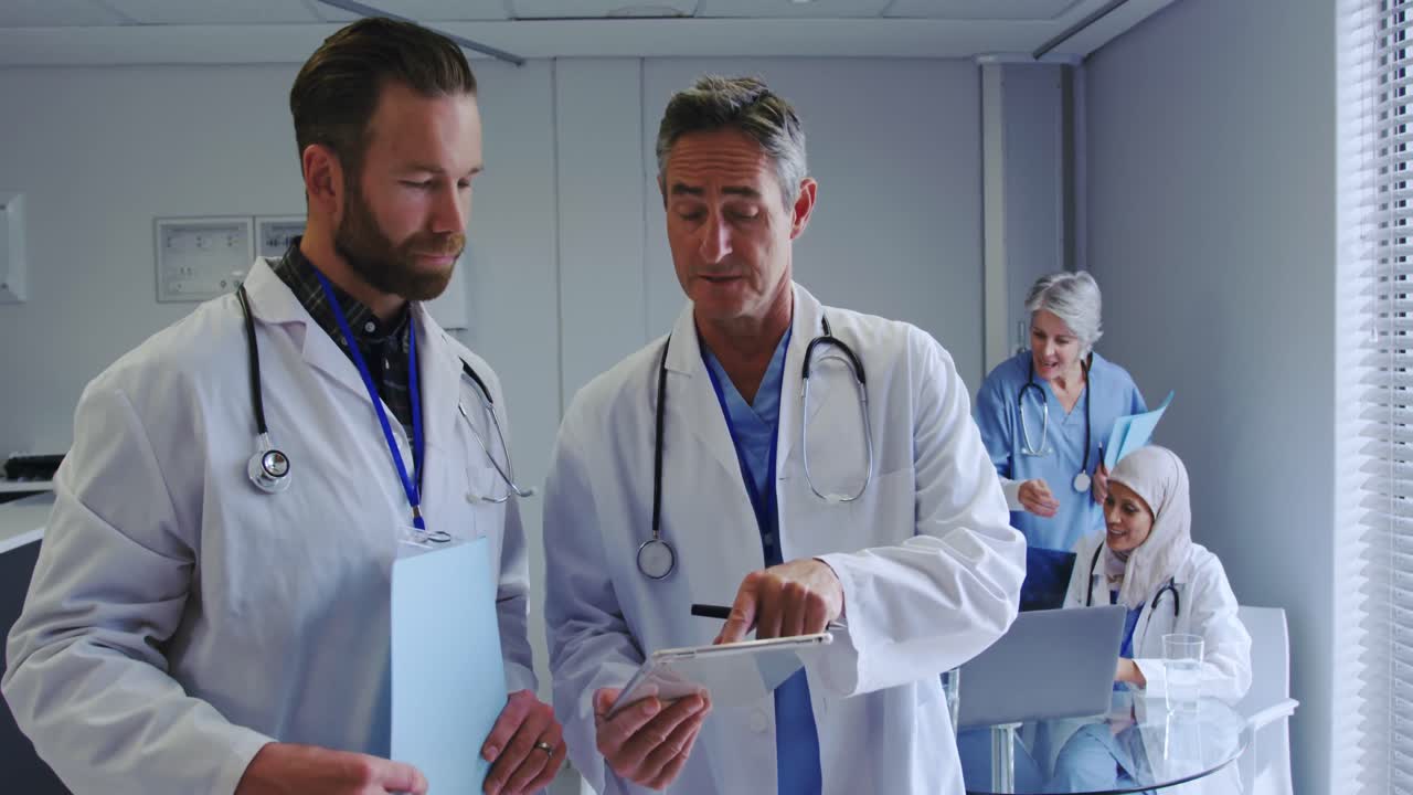 Front view of Caucasian male doctors discussing over digital tablet at hospital