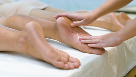 masseuse giving feet massage to man