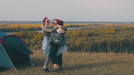 mujer joven rechoncha abraza a sus amigos con risas en el campamento