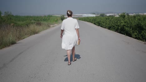 mujer caminando por un camino de campo
