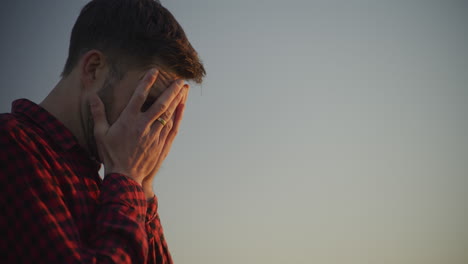 close-up of sad man against blue sky