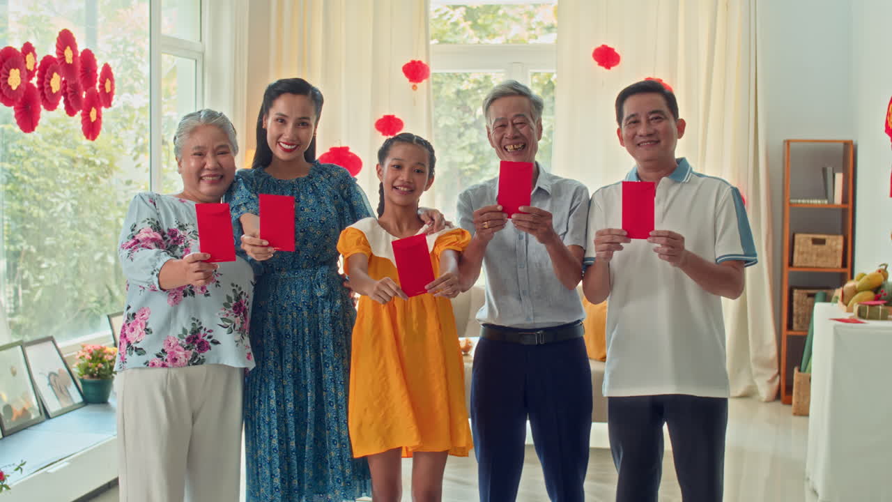 Asian Family Showing Red Envelopes on Camera during Tet Celebration