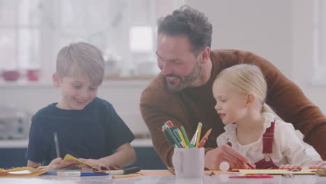padre con hijos en casa haciendo artesanía y haciendo imágenes de hojas en la cocina