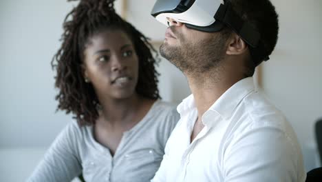 young man experiencing vr headset with assistant at office