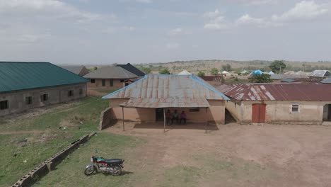 aerial - sideway drone of unpainted weathered houses in rural nigerian village