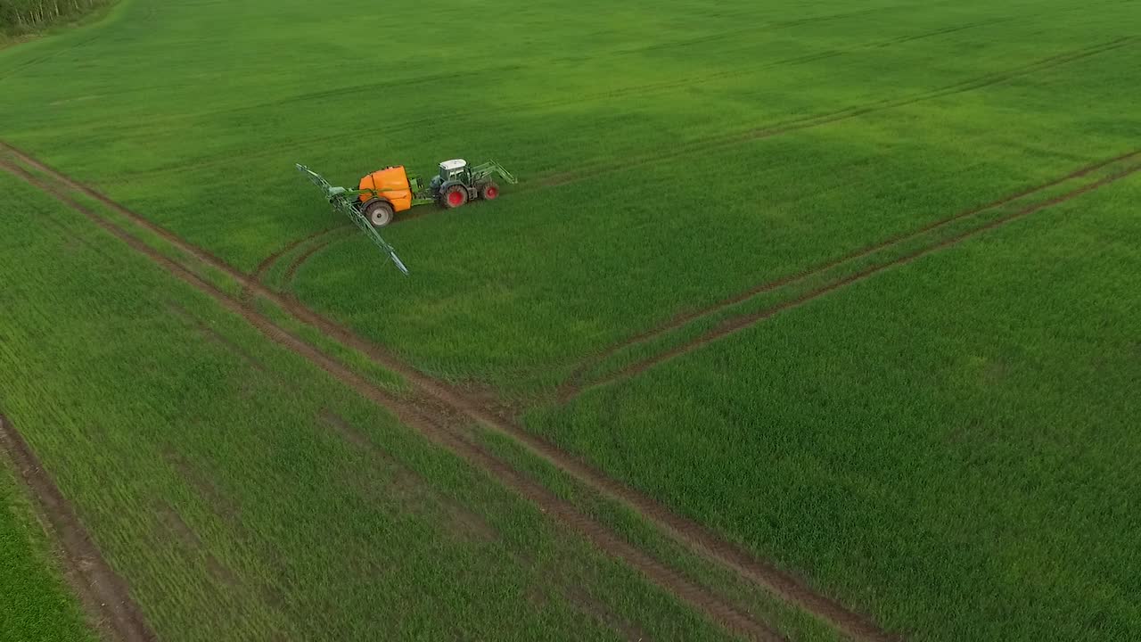 트랙터를 이용해 들판에 살충제와 비료를 뿌리는 모습