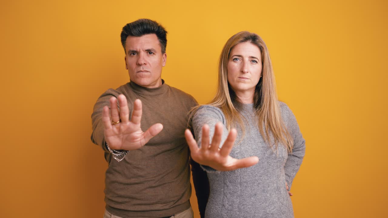 Serious Man and Woman Showing Stop Gesture