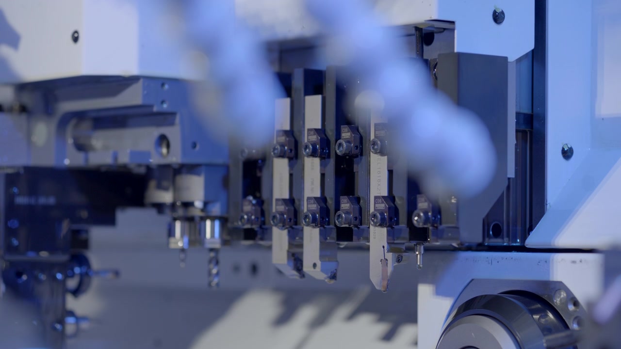 Precision CNC cutting tool positioning toward a metal workpiece inside a modern industrial machine with cinematic blue lighting.